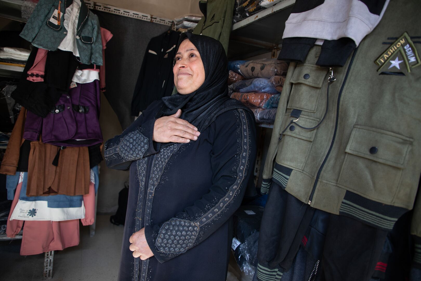 Asaliya, 49, stands inside her clothes shop in Flitah village after returning to Syria following 13 years as a refugee in Lebanon