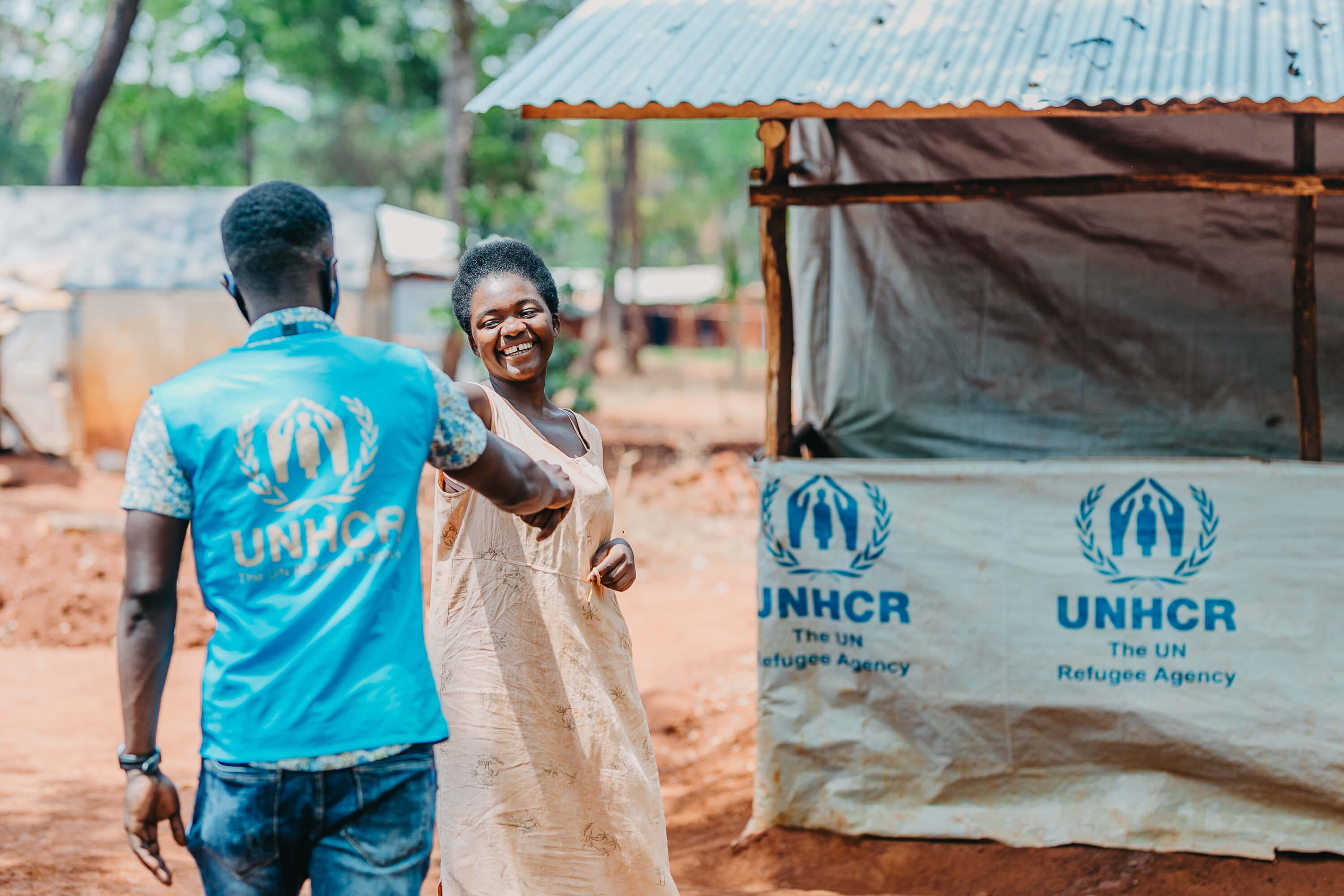 UNHCR staff worker greets a smiling refugee woman in Tanzania’s Nduta camp