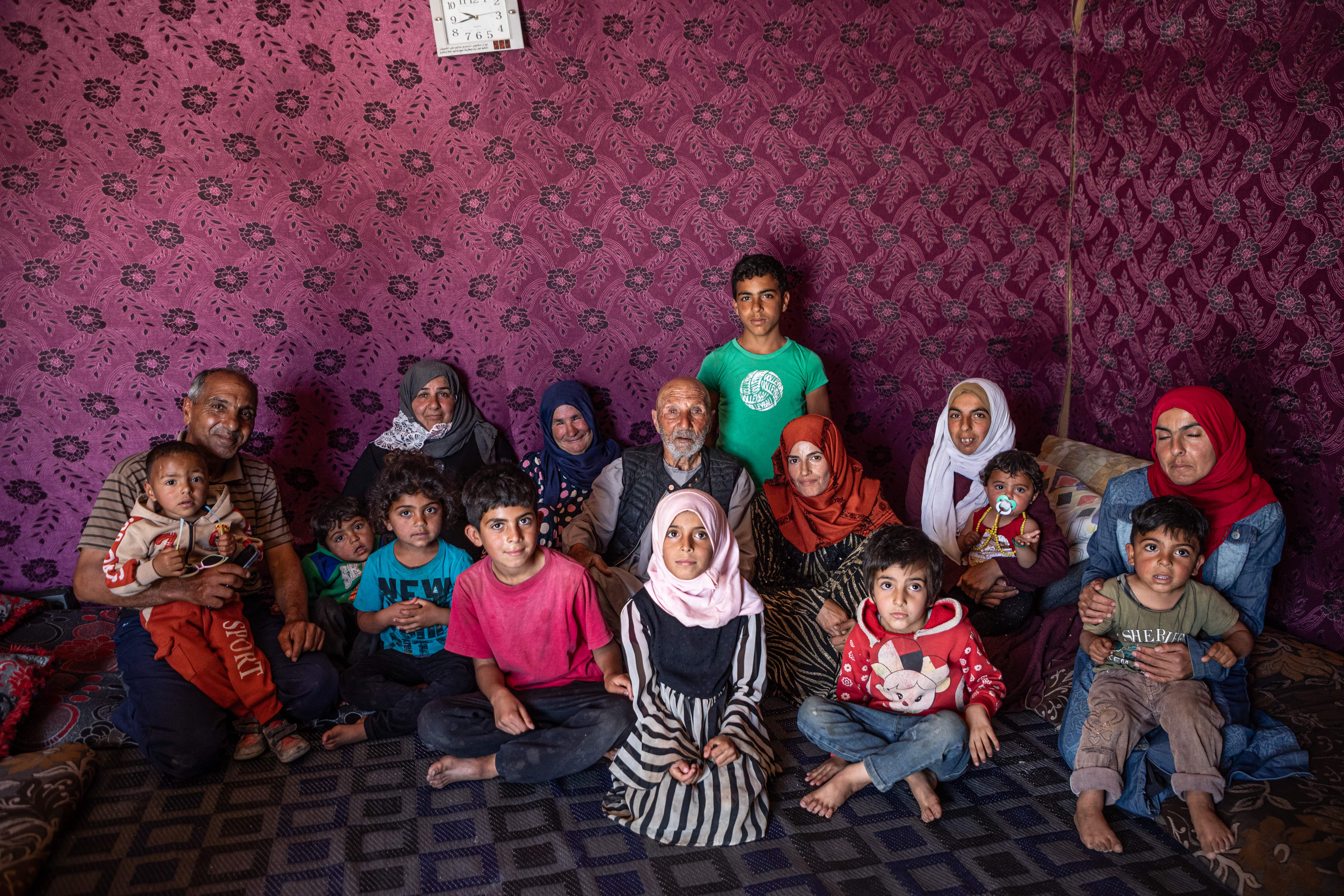 Jassim and several generations of his family sit in the tent they built on the site of their destroyed home.