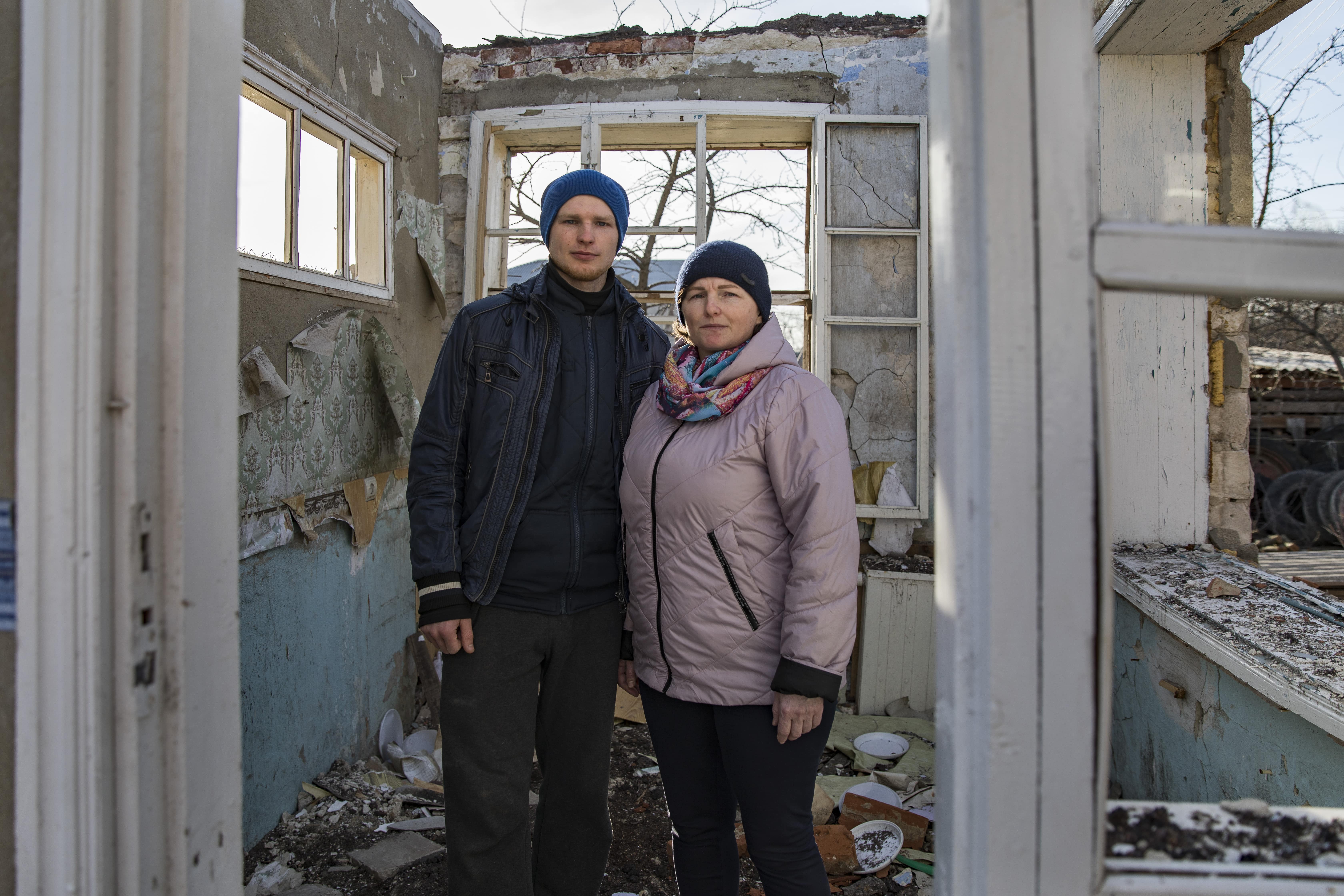 Ukraine. Vitali and his mother Halyna stand in the ruins of their home