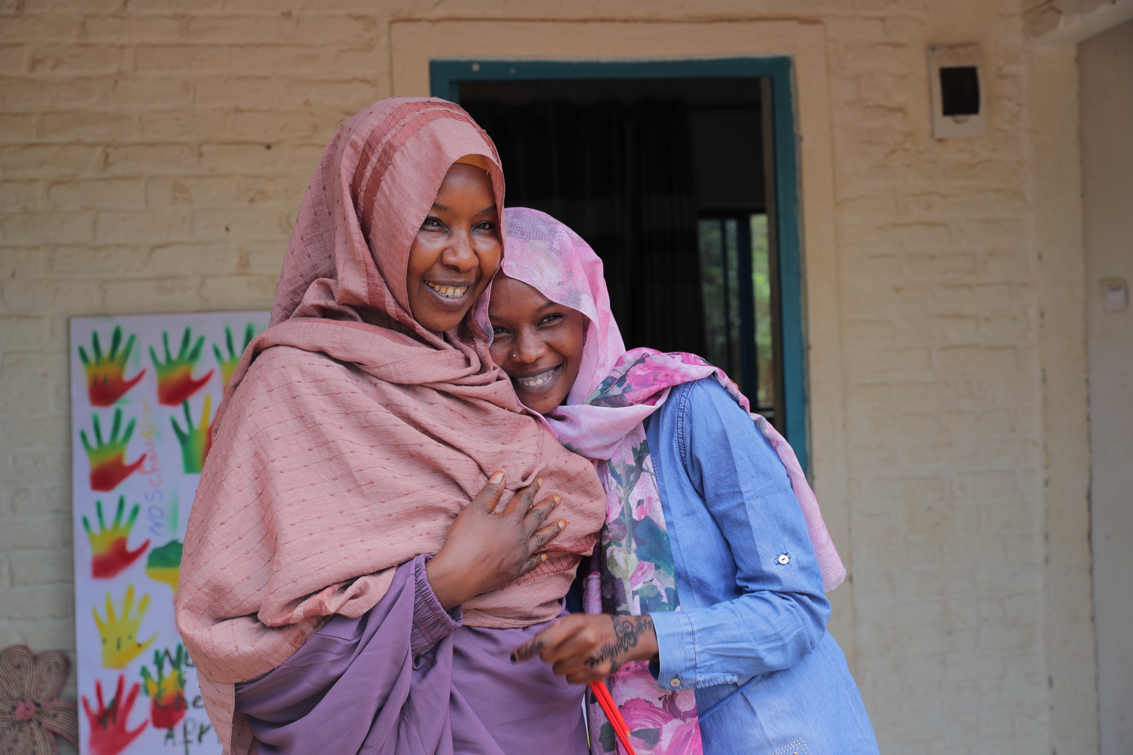 Raina and her daughter Fatima in front of their home at ETM Gashora. ETM Gashora was established in 2019 following the signature of a Memorandum of Understanding (MoU) by the Government of Rwanda, UNHCR and the African Union to rescue refugees and asylum-seekers from Libya, while continuing to search for durable solutions.