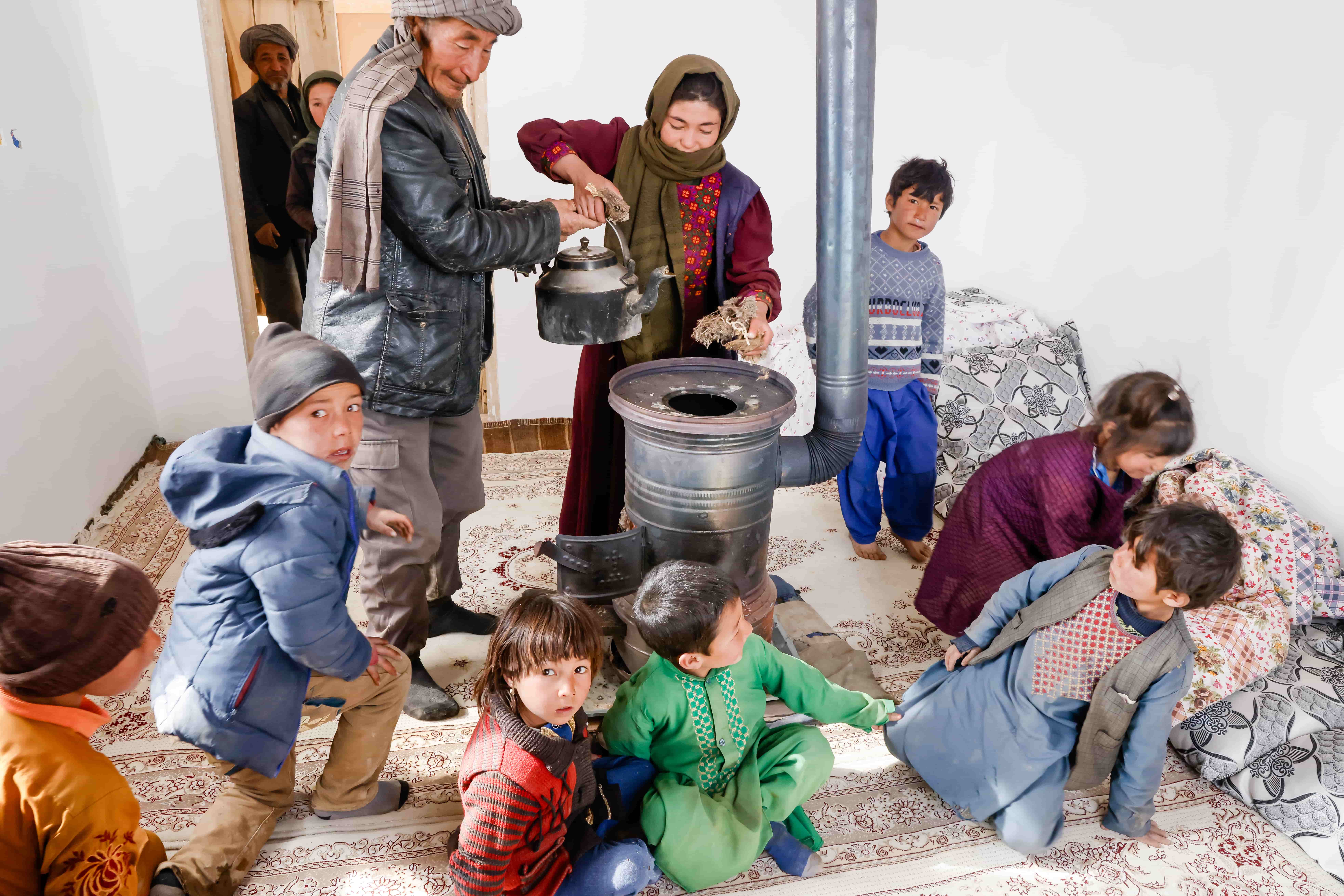 Afghanistan. Alijuma Nikbakht and his family enjoy the warmth of their new house