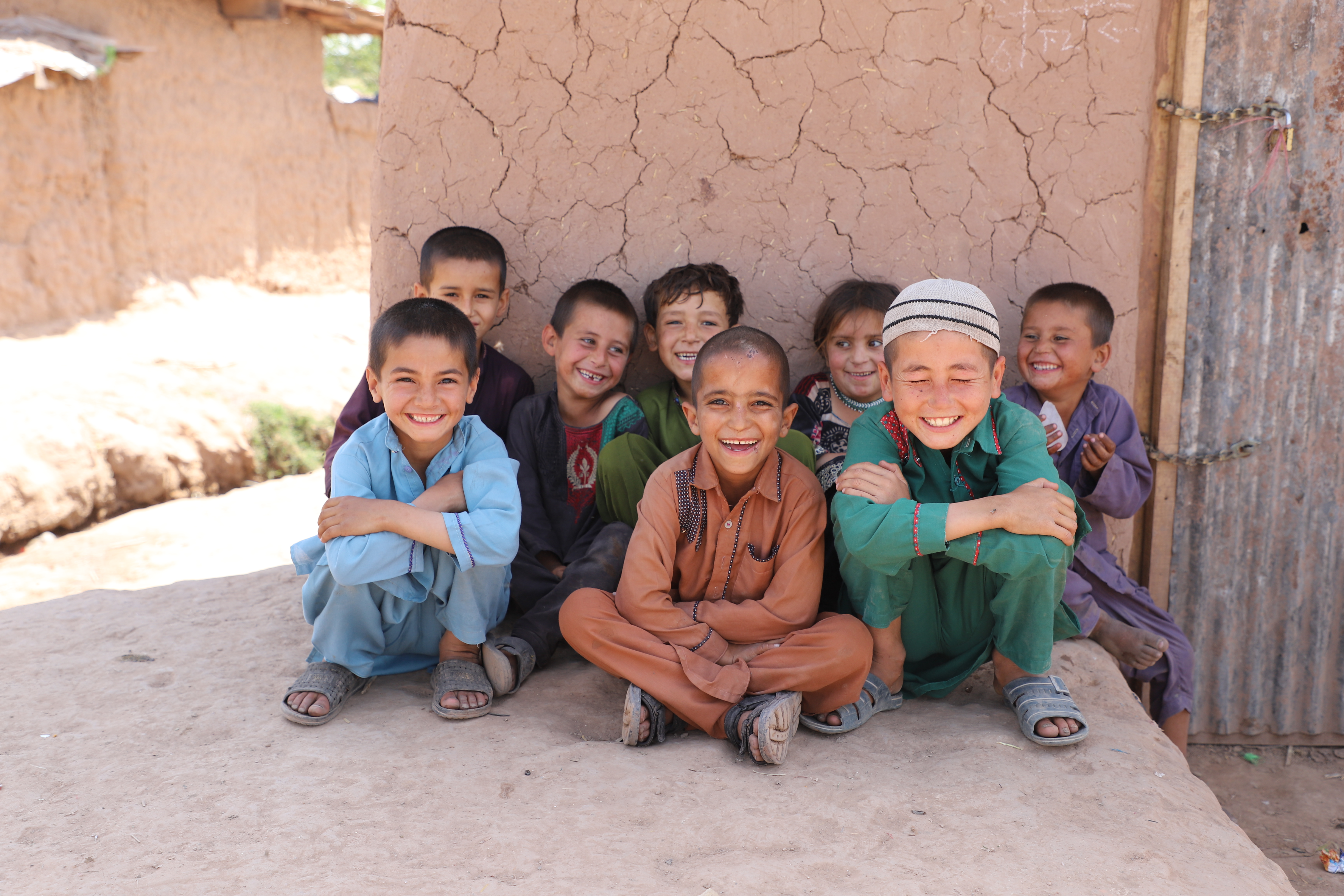 Afghan refugee children sitting and smiling in Islamabad