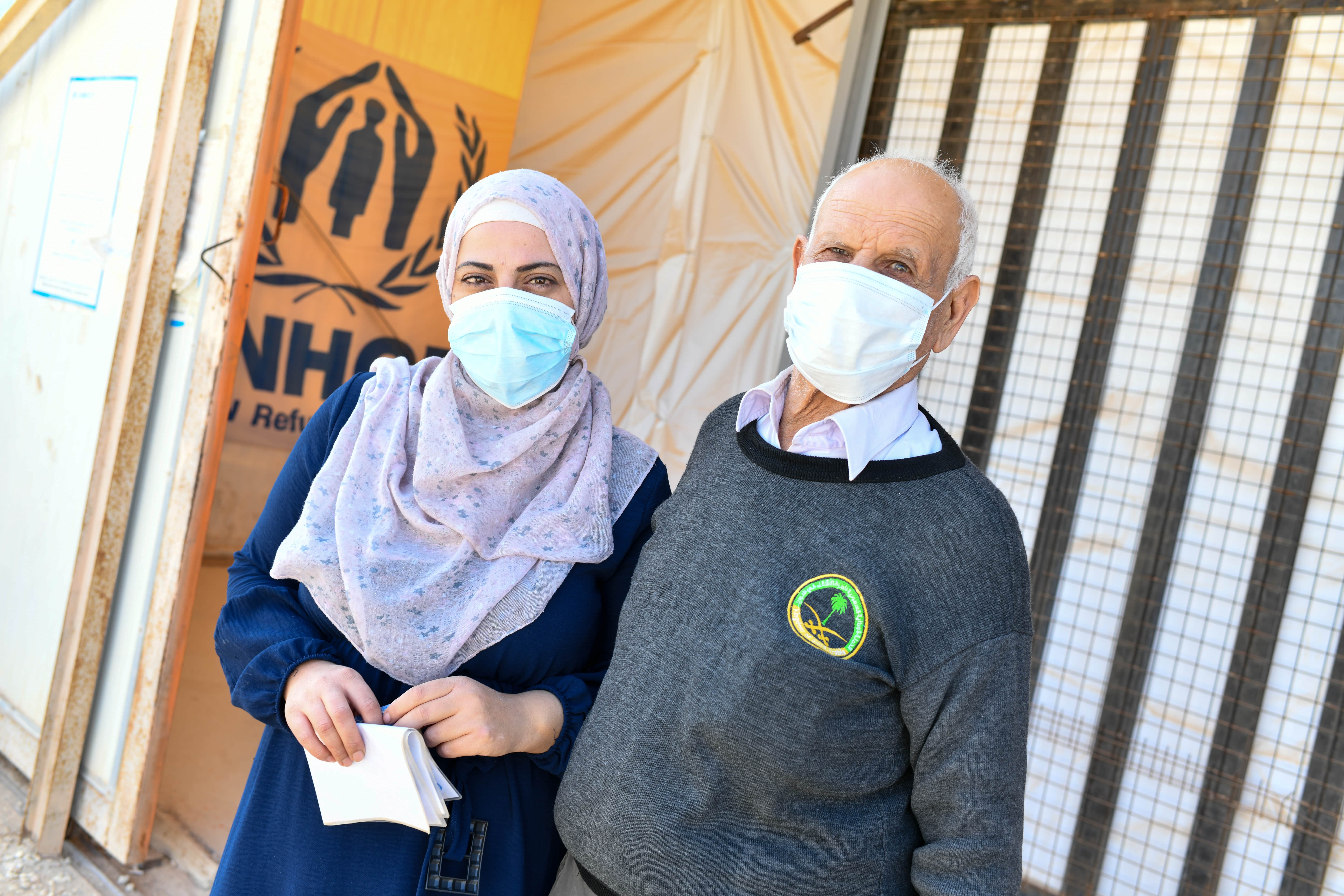 Shatha, 35, and her father Abu Safwan, 75, receive their winter cash assistance in Azraq Camp.