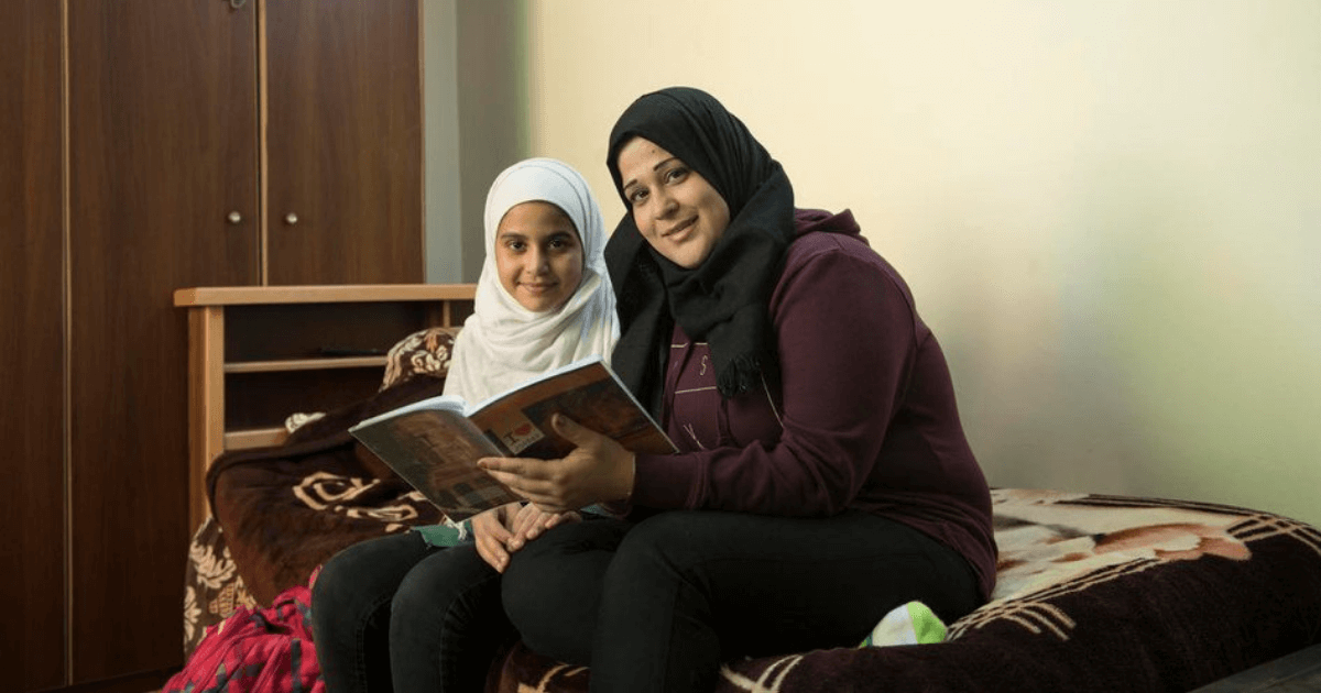 Hanaa 27, helps her daughter Joudy, 13 with her homework 