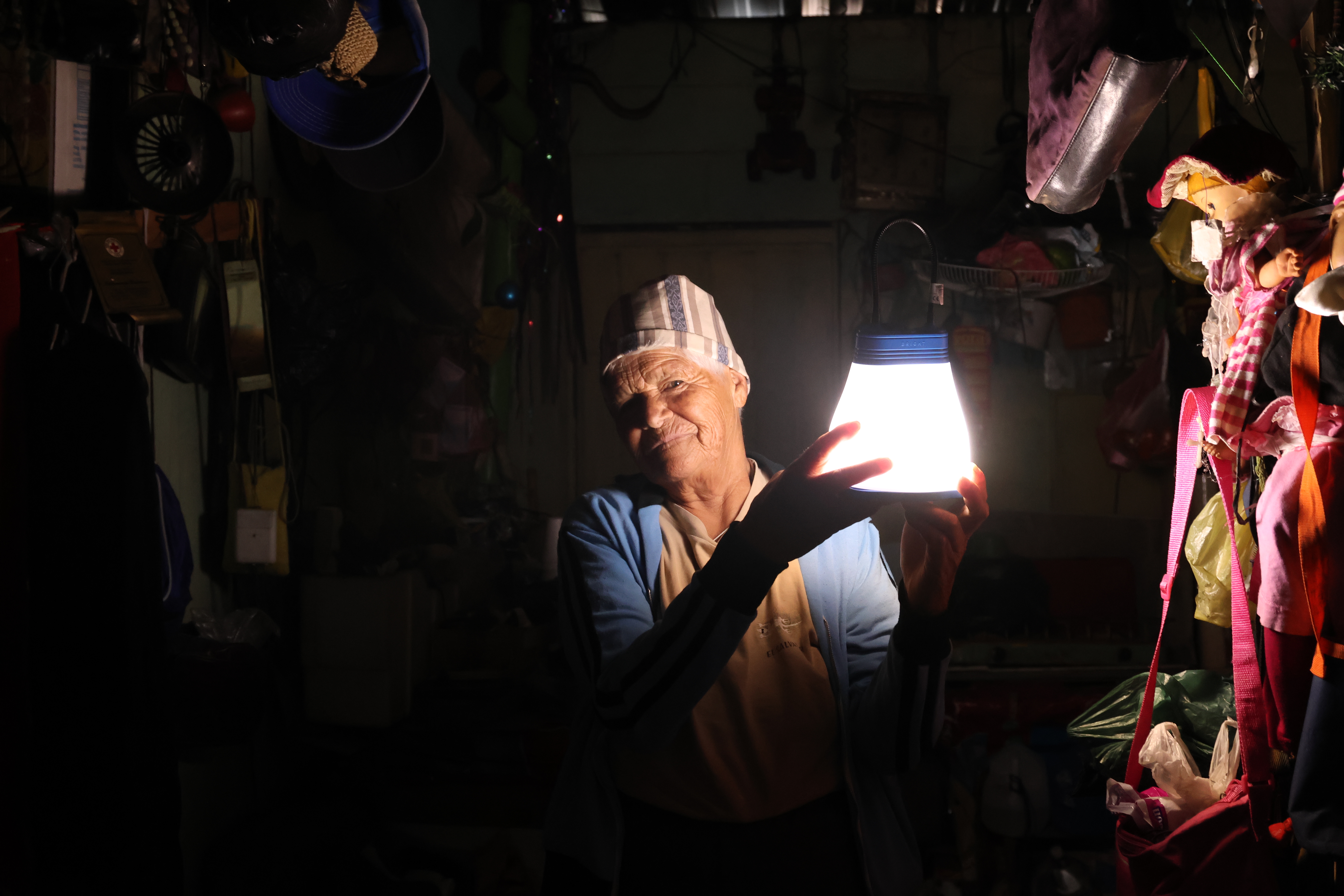 A Woman In A Rural Area Lightens Her Home With A Lamp She Received From UNHCR